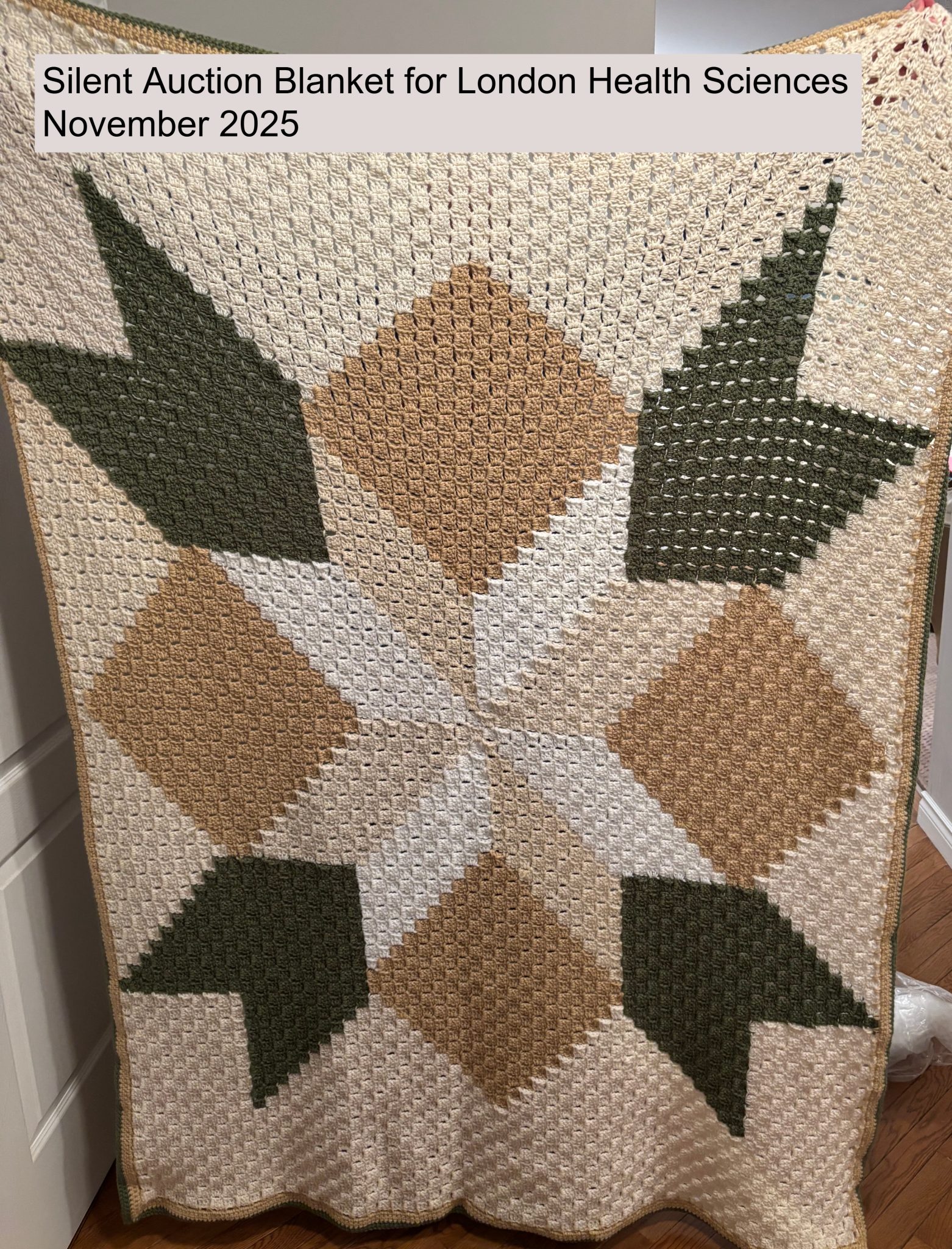 A crocheted blanket with a leaf pattern in green and tan